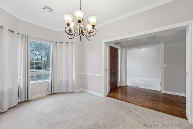 carpeted spare room featuring crown molding and an inviting chandelier