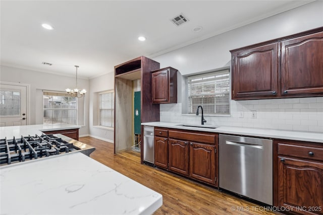 kitchen with dark wood-type flooring, sink, tasteful backsplash, dishwasher, and pendant lighting