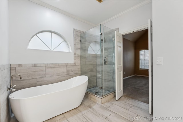 bathroom with tile walls, crown molding, and plus walk in shower