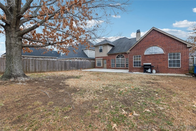 rear view of property featuring a yard and a patio