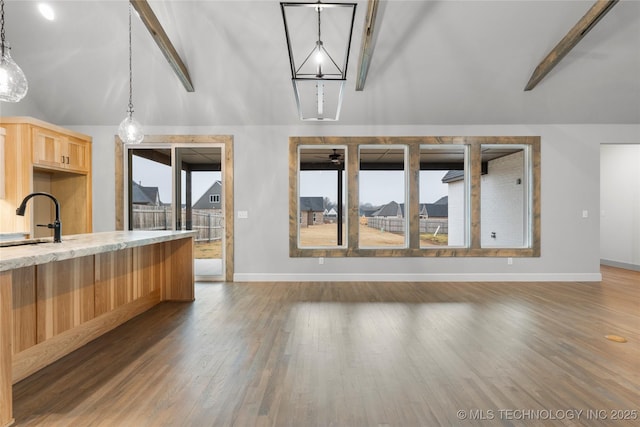 kitchen with sink, light brown cabinetry, dark hardwood / wood-style flooring, and decorative light fixtures