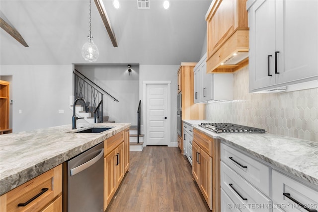 kitchen featuring pendant lighting, sink, premium range hood, white cabinetry, and stainless steel appliances