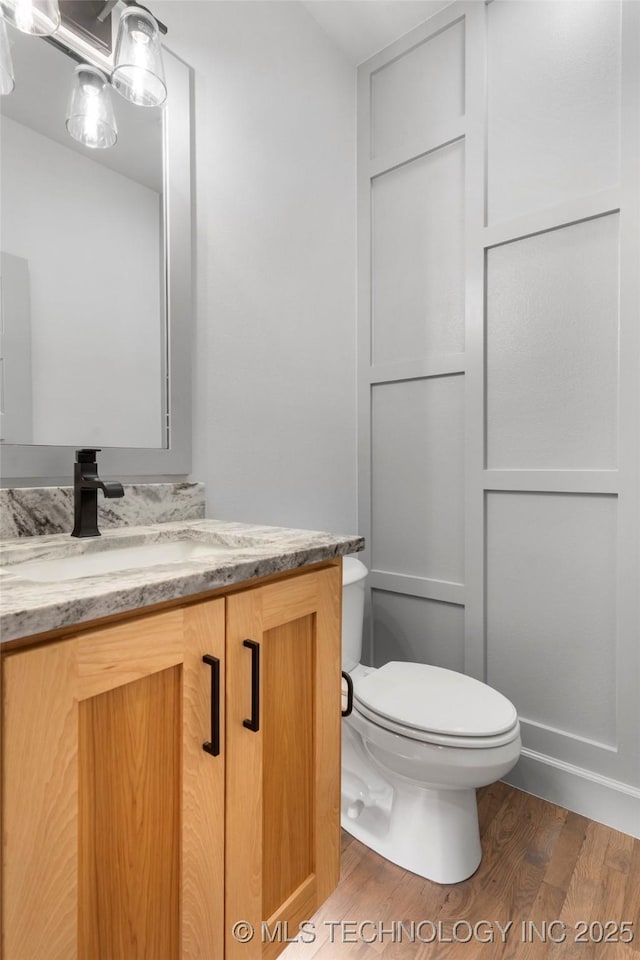 bathroom featuring hardwood / wood-style flooring, vanity, and toilet