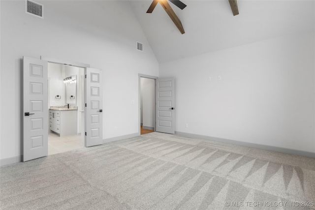 unfurnished bedroom featuring connected bathroom, high vaulted ceiling, light colored carpet, and ceiling fan