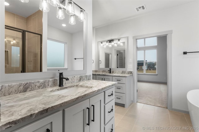 bathroom with vanity, a shower with shower door, and tile patterned floors