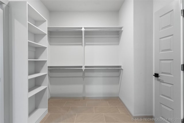 spacious closet with light tile patterned floors