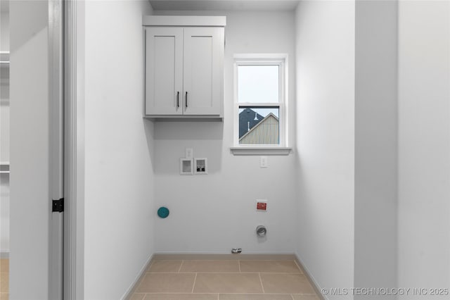 laundry area featuring gas dryer hookup, cabinets, light tile patterned floors, washer hookup, and hookup for an electric dryer