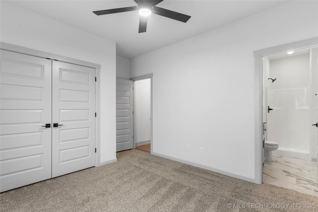 unfurnished bedroom with ensuite bathroom, ceiling fan, and a closet