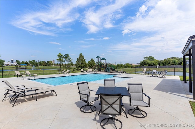 view of pool with a water view and a playground