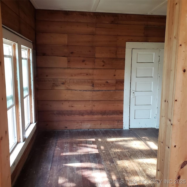 empty room featuring dark hardwood / wood-style flooring and wood walls