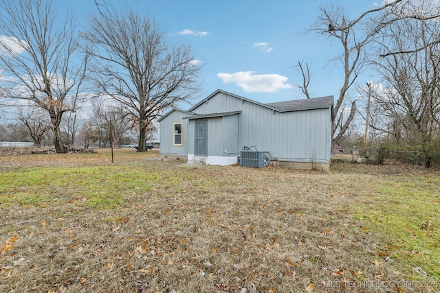 view of outdoor structure with central AC and a lawn