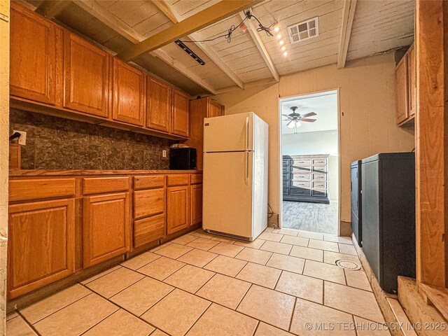 kitchen with white refrigerator, ceiling fan, beam ceiling, and light tile patterned floors