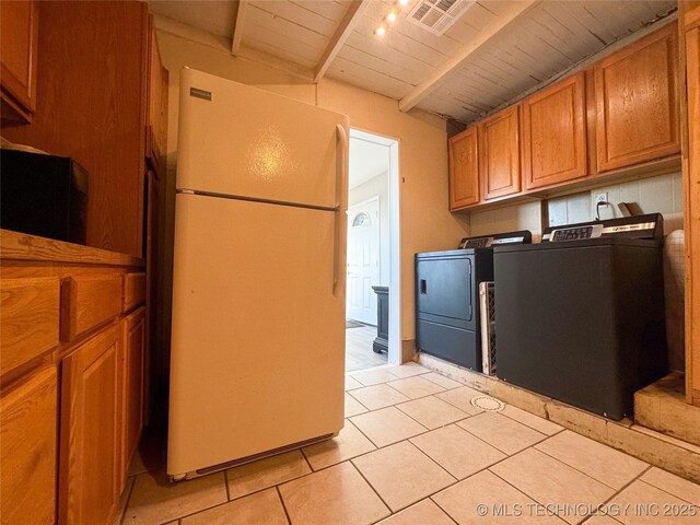 laundry room featuring light tile patterned flooring, wooden ceiling, and washing machine and clothes dryer