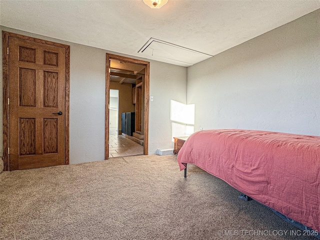 bedroom with light colored carpet and a textured ceiling