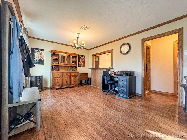 office space featuring an inviting chandelier, ornamental molding, light hardwood / wood-style floors, and a textured ceiling