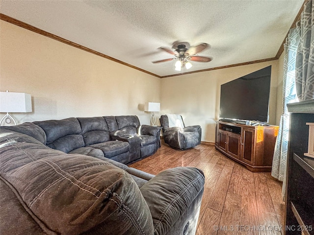 living room featuring crown molding, ceiling fan, hardwood / wood-style floors, and a textured ceiling