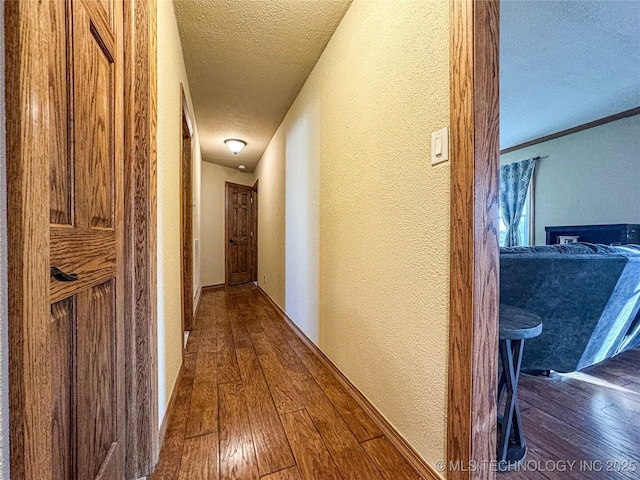 hallway with dark wood-type flooring and a textured ceiling