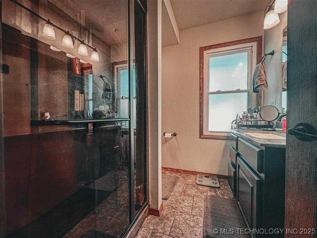 bathroom with a shower with door and vanity