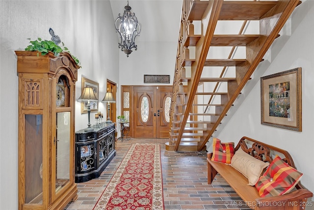 entryway featuring a towering ceiling and a chandelier