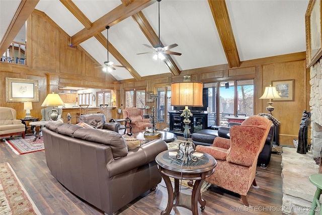 living room with wooden walls, dark hardwood / wood-style floors, and beamed ceiling