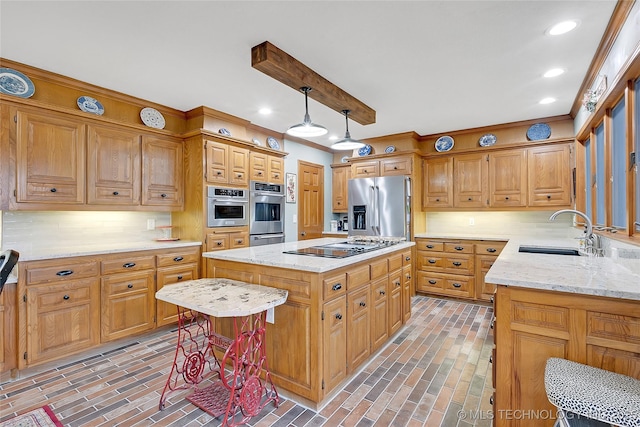 kitchen featuring sink, hanging light fixtures, appliances with stainless steel finishes, a kitchen island, and decorative backsplash