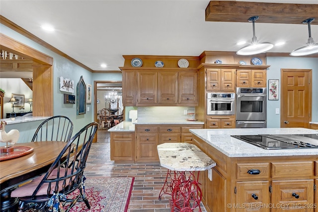 kitchen featuring pendant lighting, crown molding, double oven, a center island, and black electric stovetop