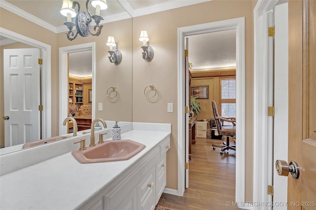 bathroom with crown molding, hardwood / wood-style floors, vanity, and a textured ceiling