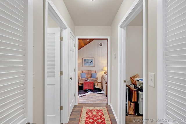 hall with vaulted ceiling and hardwood / wood-style floors