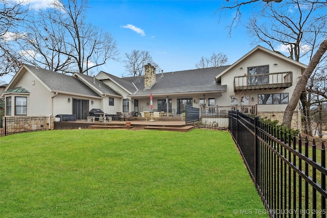 rear view of house with a wooden deck, a yard, and a balcony