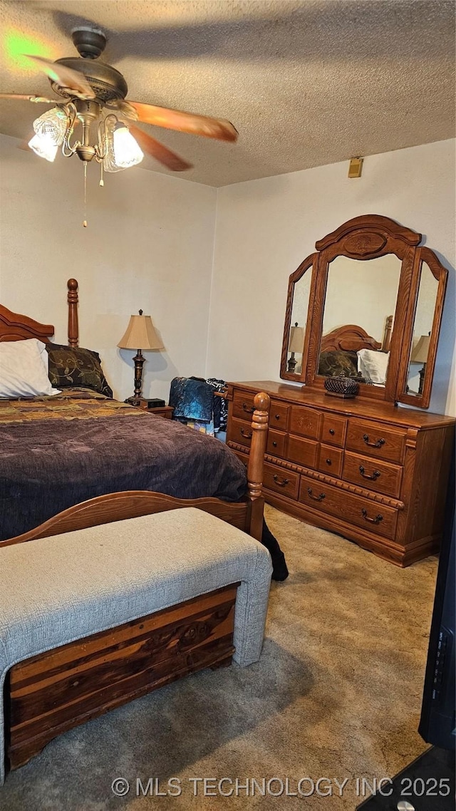 carpeted bedroom with ceiling fan and a textured ceiling