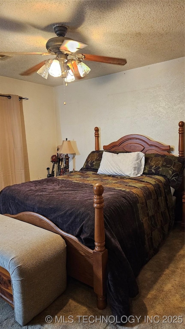 carpeted bedroom featuring ceiling fan and a textured ceiling