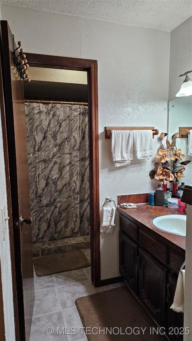 bathroom with vanity, a textured ceiling, and a shower with curtain