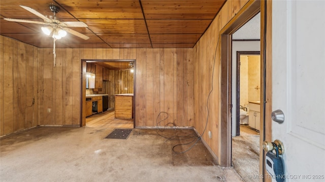 empty room with ceiling fan, wooden ceiling, and wooden walls