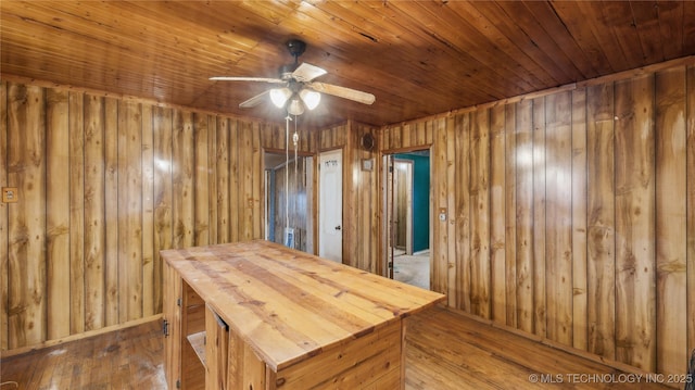 interior space with wood ceiling, ceiling fan, wooden walls, and hardwood / wood-style floors