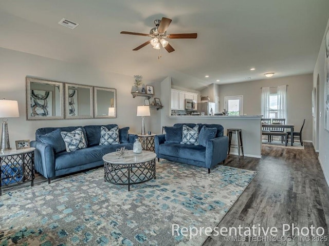 living room featuring ceiling fan, wood-type flooring, and vaulted ceiling