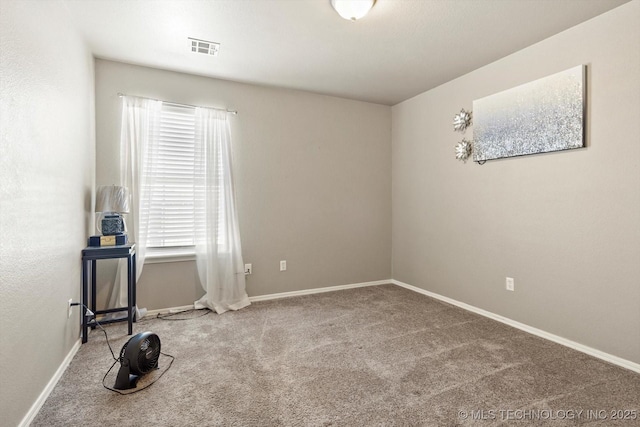 empty room featuring carpet, visible vents, and baseboards