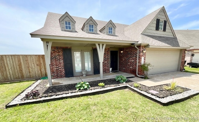 view of front of home featuring covered porch, brick siding, fence, and a front yard