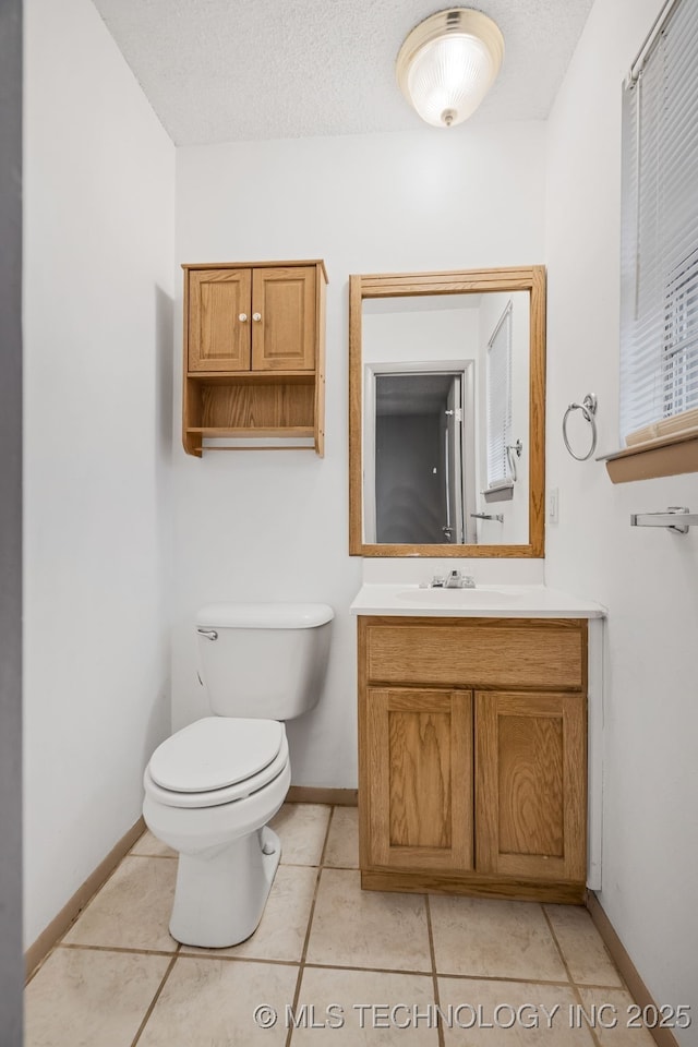 bathroom with tile patterned floors, vanity, toilet, and a textured ceiling