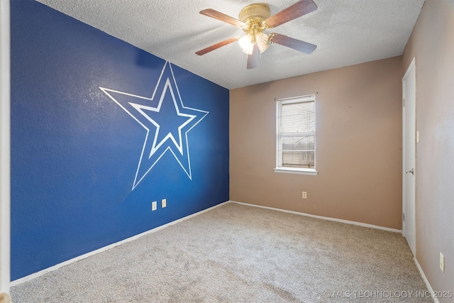 unfurnished room with ceiling fan, carpet, and a textured ceiling