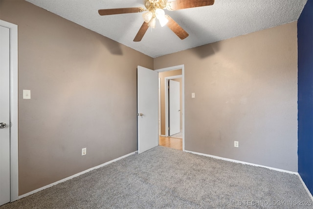 empty room featuring ceiling fan, light colored carpet, and a textured ceiling