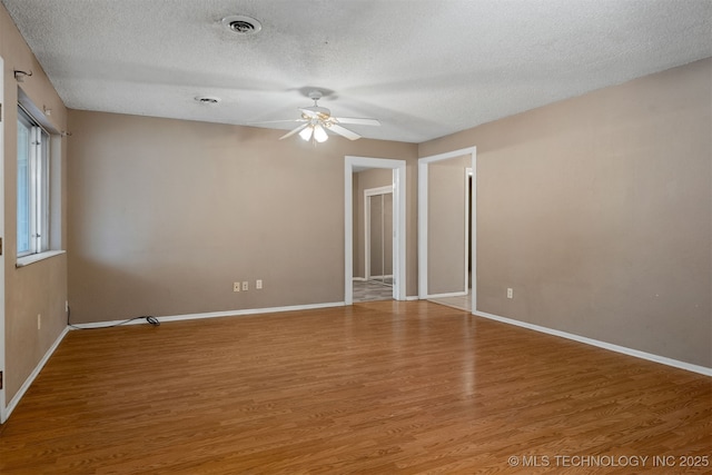 spare room featuring ceiling fan, hardwood / wood-style flooring, and a textured ceiling