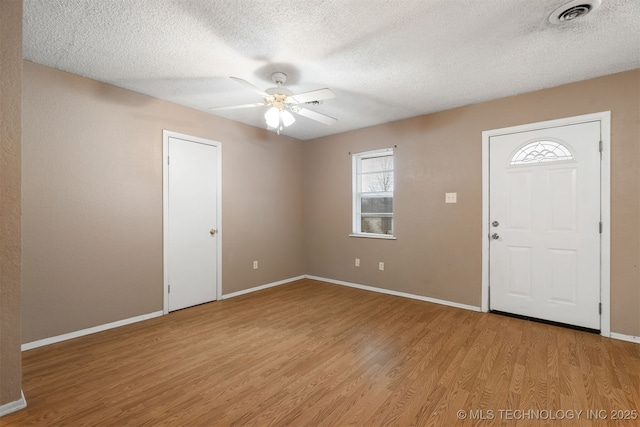 entryway featuring ceiling fan, light hardwood / wood-style flooring, and a textured ceiling