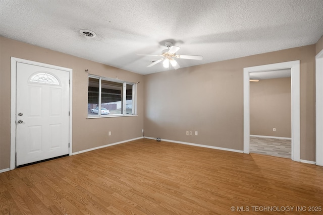 entrance foyer with ceiling fan, a textured ceiling, and light hardwood / wood-style floors