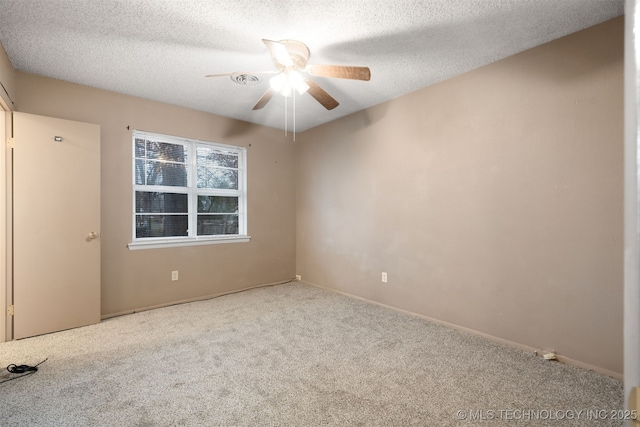 empty room with ceiling fan, carpet floors, and a textured ceiling