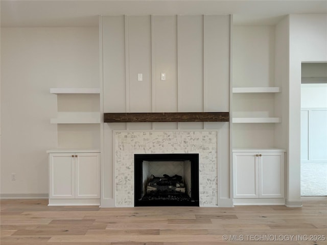 details featuring hardwood / wood-style flooring, a tile fireplace, and built in shelves