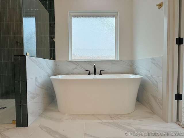 bathroom featuring shower with separate bathtub and tile walls