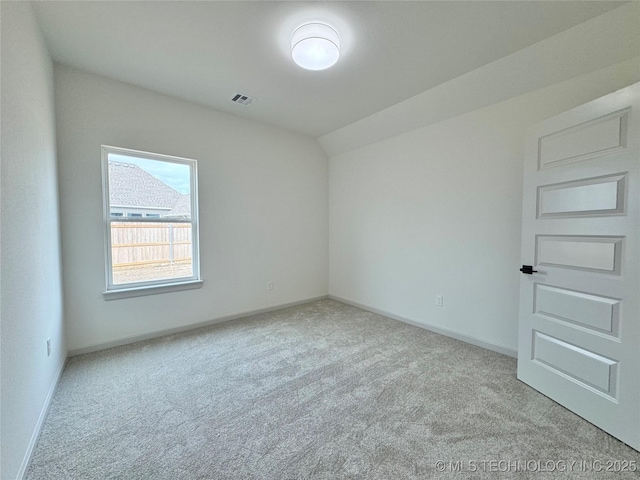 unfurnished room with lofted ceiling and light colored carpet