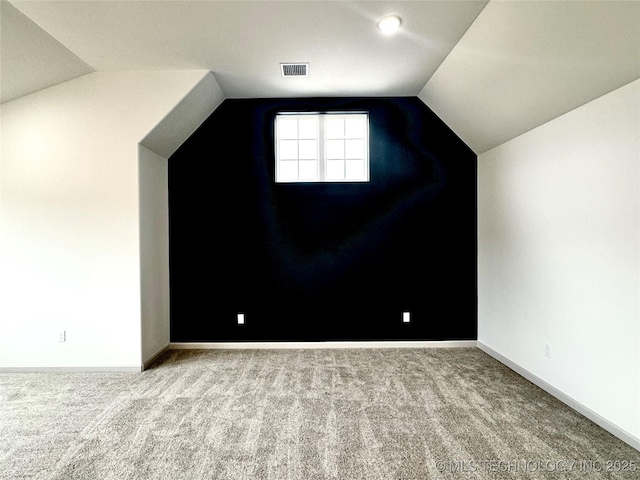 bonus room with carpet floors and vaulted ceiling