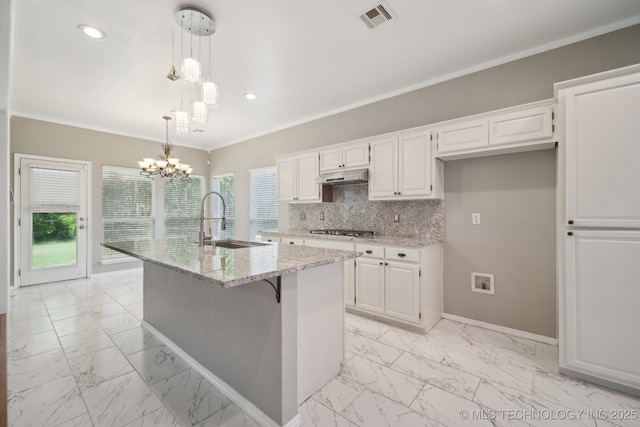 kitchen featuring a sink, marble finish floor, stainless steel gas stovetop, under cabinet range hood, and visible vents