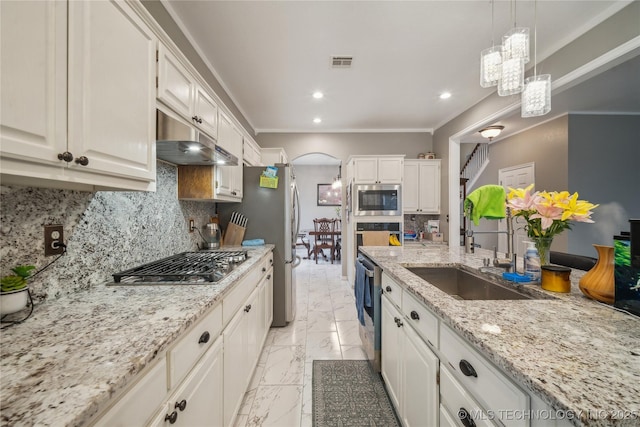 kitchen featuring sink, hanging light fixtures, white cabinets, stainless steel appliances, and backsplash